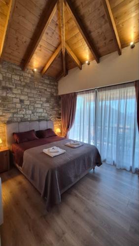 a bedroom with a bed and a stone wall at Stone Loft in Karpenisi