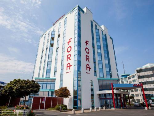 a tall white building with a sign on it at Fora Hotel Hannover by Mercure in Hannover