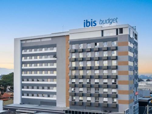 a building with a hilton hotel on top of it at ibis budget Pindamonhangaba in Pindamonhangaba