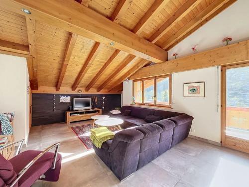 a living room with a couch and a tv at L Eau Vive Combles in Le Châble