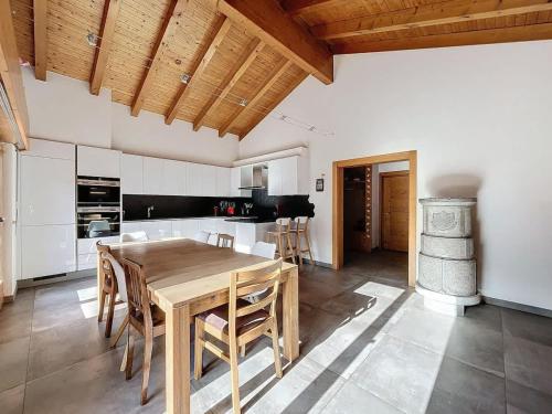 a large kitchen with a wooden table and chairs at L Eau Vive Combles in Le Châble