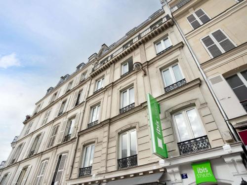 a large building with a green sign on it at ibis styles Paris Montmartre Batignolles in Paris