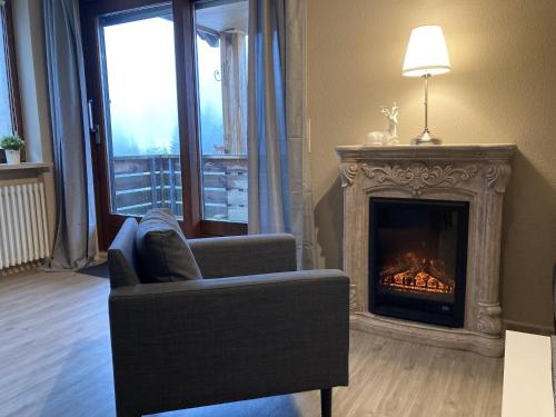 a living room with a chair and a fireplace at Ferienwohnung Tannenhöh in Todtmoos
