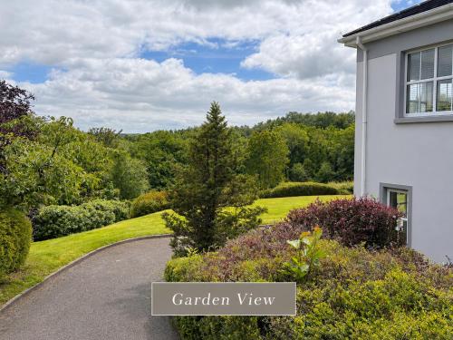 a driveway leading to a white house with a garden view at Sonas in Letterkenny