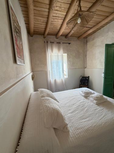 a white bed in a room with a window at Casa Limón in Bodonal de la Sierra