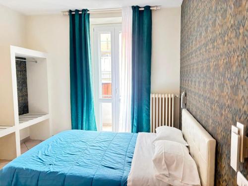 a bedroom with a blue bed and a window at Pasubio House appartamento in Campobasso