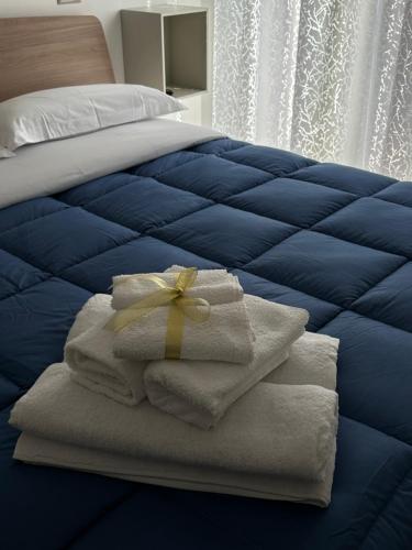 a blue bed with towels and a bow on it at B&B le Pontine in Gaeta