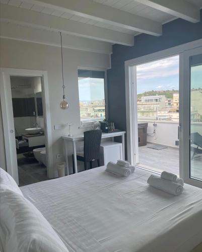 a bedroom with a white bed with two towels on it at 18 Dante Luxury Suites in Cagliari