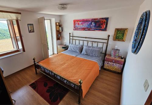 a bedroom with a bed with an orange blanket and blue pillows at Casa Mersino in Lindar
