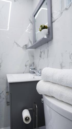 a bathroom with a sink and a toilet with towels at Bright & Comfortable 2BR San Juan Getaway in San Juan