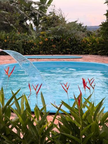 a blue swimming pool with a water fountain at Pousada Shopping do Sono in Jaciara