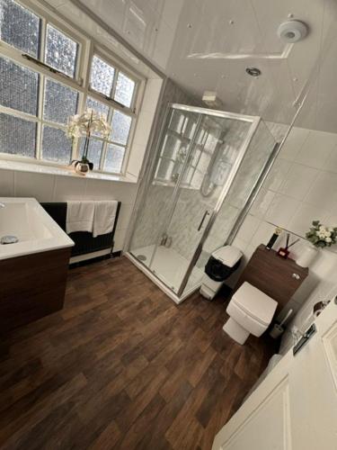 a bathroom with a shower and a toilet and a sink at Wakefield Town House Accomodation in Wakefield