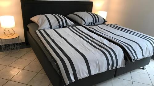 a bed with a black and white striped comforter at Blue-House Mosel in Piesport