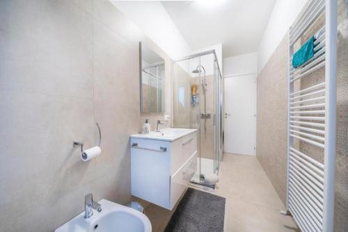 a white bathroom with a sink and a shower at Mirella's cute place Udine in Udine