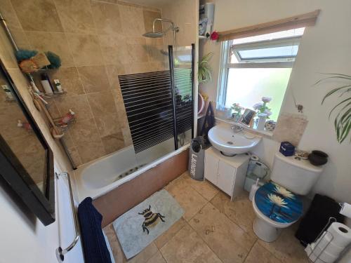 a bathroom with a shower and a toilet and a sink at BEE KIND available with shared bathroom in Glastonbury