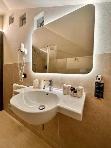 a bathroom with a white sink and a mirror at Tenuta Baràc in Alba