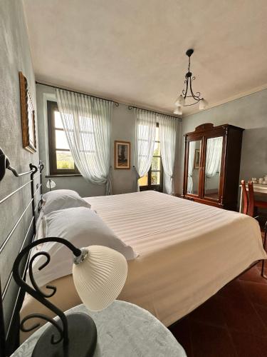 a bedroom with two beds and a lamp at Tenuta Baràc in Alba