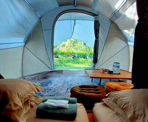 a tent with a bed and a table and a window at Edy's Farm Cottage in Jabon