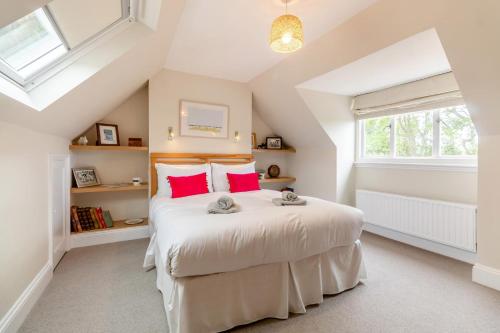 a bedroom with a large white bed with red pillows at 5 Bed in Walberswick oc-hlodg2 in Walberswick