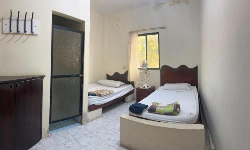 a bedroom with two beds and a window in it at Auto Hostal Jaramisol in Jaramijó