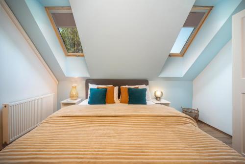 a bedroom with a large bed with blue walls and windows at Rita Apartman in Balatonföldvár