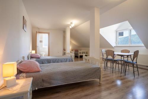 sypialnia z dwoma łóżkami, stołem i krzesłami w obiekcie Guesthouse Viktorija Flat - Deluxe Apartment w mieście Otočac