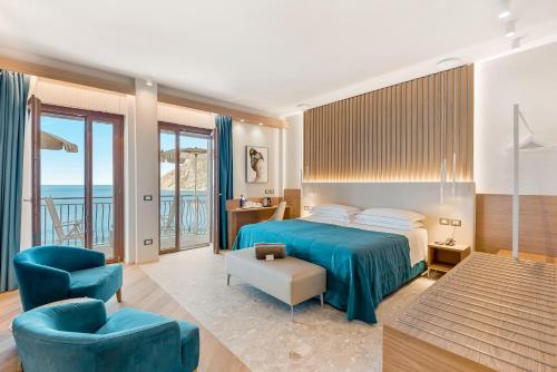 ein Schlafzimmer mit einem blauen Bett und einem blauen Stuhl in der Unterkunft Hotel Porto Roca in Monterosso al Mare