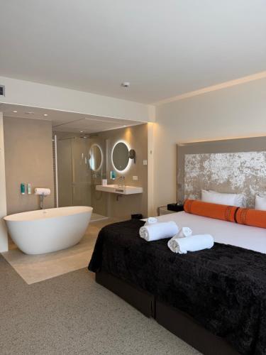 a bedroom with a large bed and a bath tub at Le Chateau Des Thermes in Chaudfontaine