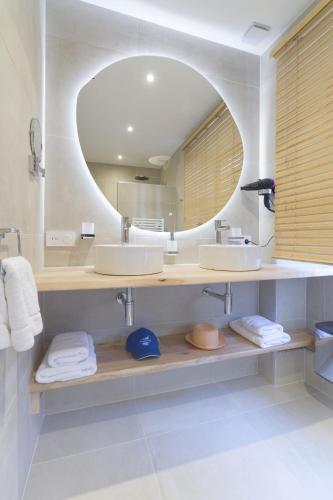 a bathroom with two sinks and a large mirror at Le Domaine de Falgos Golf & Spa in Saint-Laurent-de-Cerdans