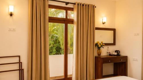 a bedroom with a window and a bed and a mirror at The Oak Residence in Ragama