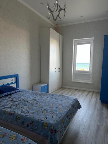 a bedroom with a blue bed and a window at Royal resort in Aktau