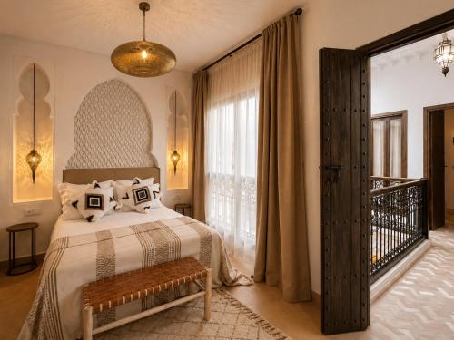 a bedroom with a bed and a large window at Riad privé Maskat, piscine, petit-déjeuners, proche Jemaa el-Fna in Marrakesh