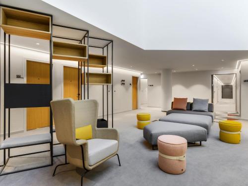 a room with couches and chairs in a room at ibis Budapest Stadium in Budapest