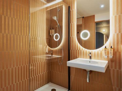 a bathroom with a sink and a shower at Mercure Saint Raphael Centre Plage in Saint-Raphaël