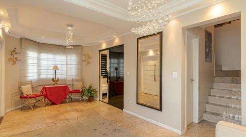 a living room with a table and a mirror at Pavilhão Egípcio in Curitiba