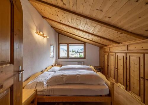 a large bed in a room with a wooden ceiling at Zimmer in Celerina in Celerina