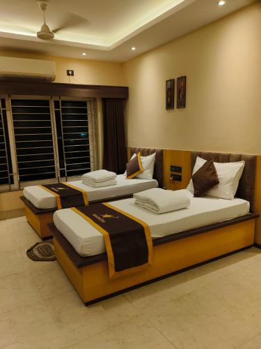 two beds in a room with at NAKSHATRA Hotel, Restaurant & Banquet in Barddhamān