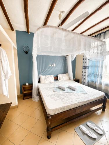 a bedroom with a bed with a canopy at Simba Apartments in Diani Beach