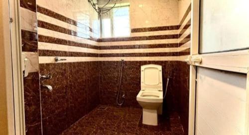 a bathroom with a toilet with stripes on the wall at Hotel Hill Edge in Kodaikānāl