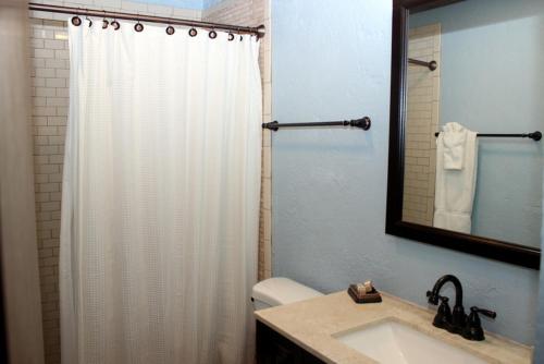 a bathroom with a shower curtain and a sink at Point Pleasant Resort® 1BR Suite with Ocean Views in Nazareth
