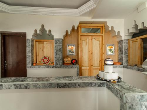 a kitchen with marble counter tops and wooden cabinets at TAMOUNT Surf House in Agadir