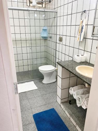 a bathroom with a toilet and a sink at Casa na praia bem localizada in Marataizes