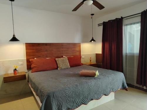 a bedroom with a large bed with red pillows at Hotel La Casa del Capi in Holbox Island