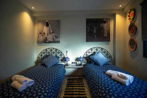 a bedroom with two beds with blue pillows at Alojamientos Chaouni in Chefchaouen