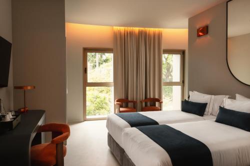 a hotel room with a bed and a large window at Moon & Sun Funchal in Funchal