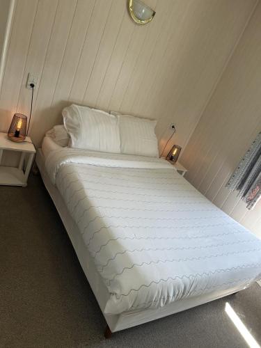 a large white bed in a room with two lamps at Au Bon Accueil in Alban