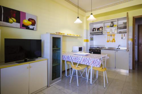 een keuken met een tafel met stoelen en een televisie bij Holiday House Naxos in Giardini Naxos