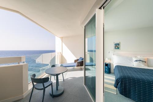 a bedroom with a bed and a table and chairs at The Salmar - Adults Only in San Miguel de Abona