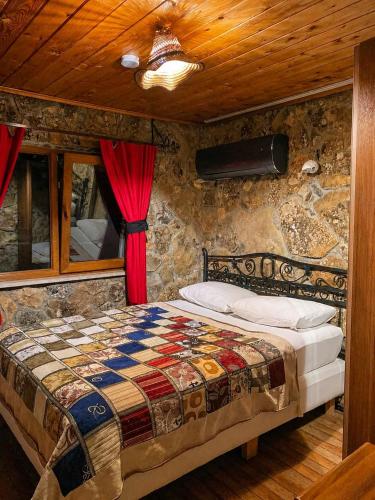 a bedroom with a bed in a stone wall at Uysallar Koy Evi in Gokceada Town