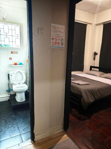 a small room with a toilet and a bed at Dreamcatcher Bangkok in Bangkok